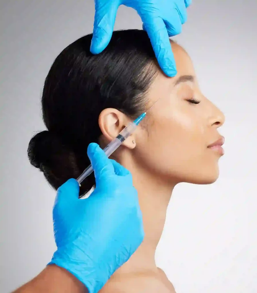 Closeup of a gorgeous mixed race woman getting botox filler. Hispanic model getting filler to reduce wrinkles against a grey copyspace background in a studio